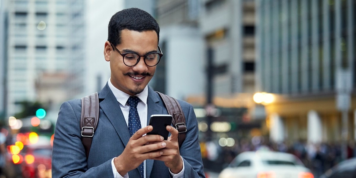 hombre parado afuera con celular, ciudad